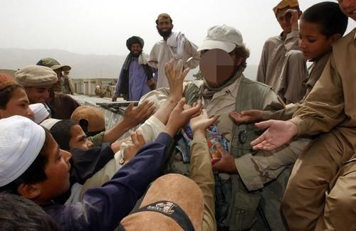 SPECIAL FORCES SOLDIER GIVING OUT CANDY TO CHILDREN IN AFGHANISTAN